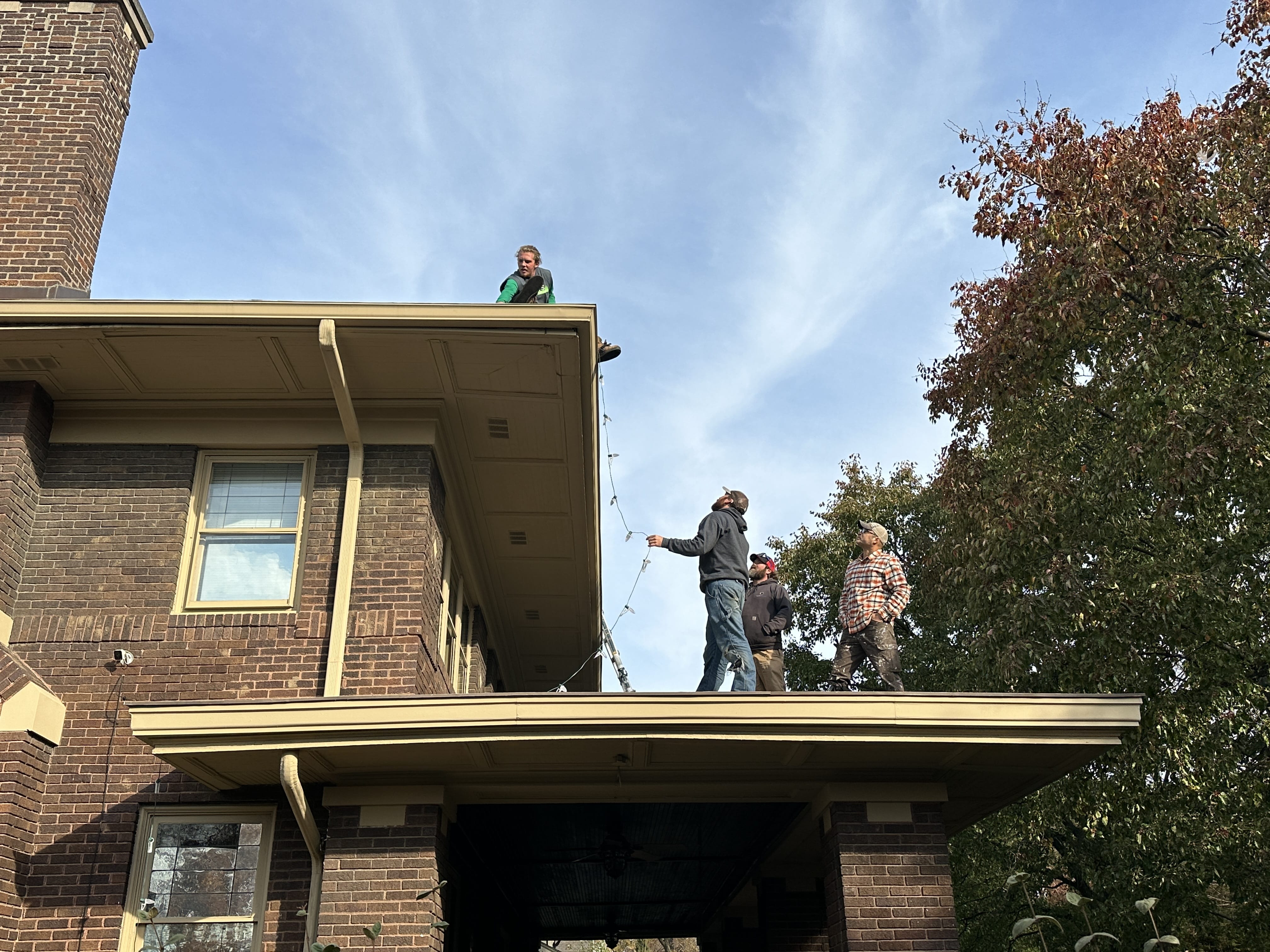 Technician removing Christmas lights from roof