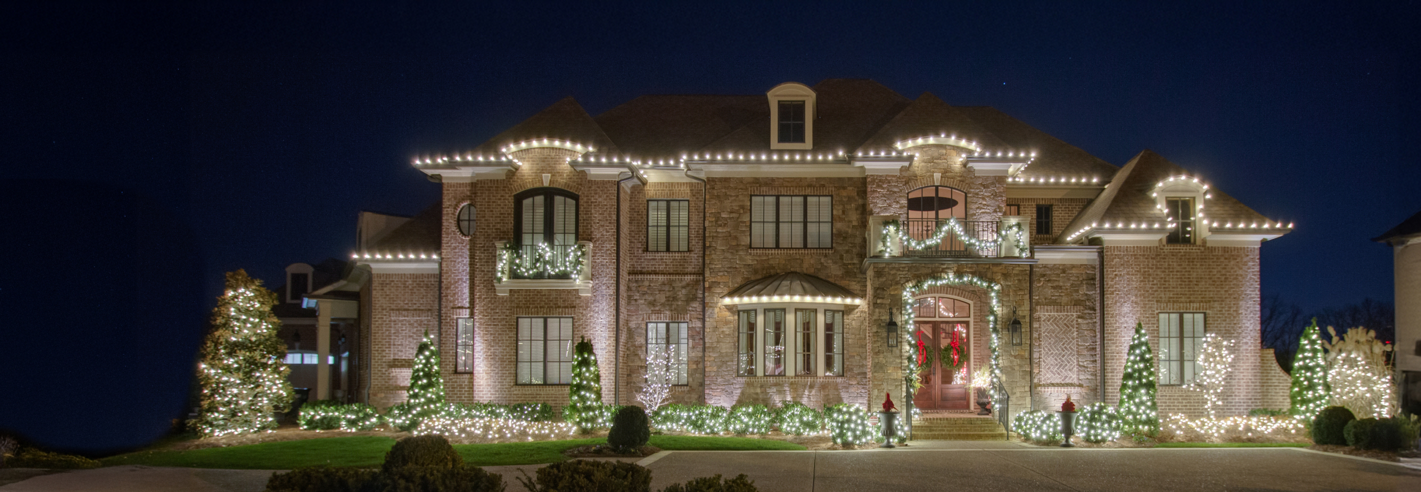 Two-story home decorated with Christmas lights and wreaths